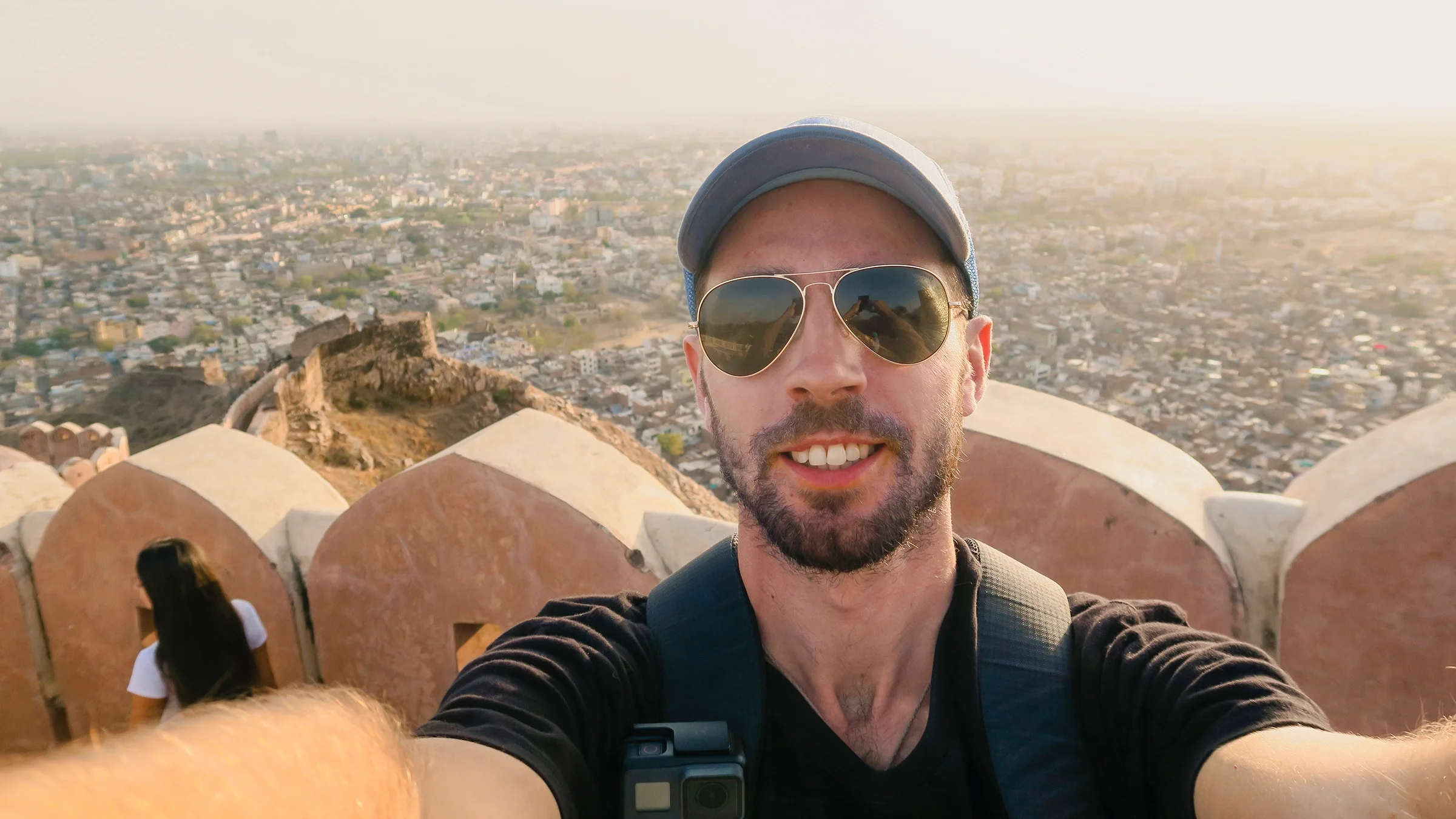 Man taking selfie with city view in the background.