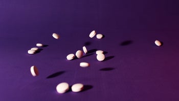 Health: Melatonin: pink pills on purple background 1294011827