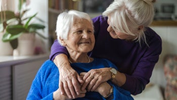 caregiving: woman hugging elderly mother 1446913169