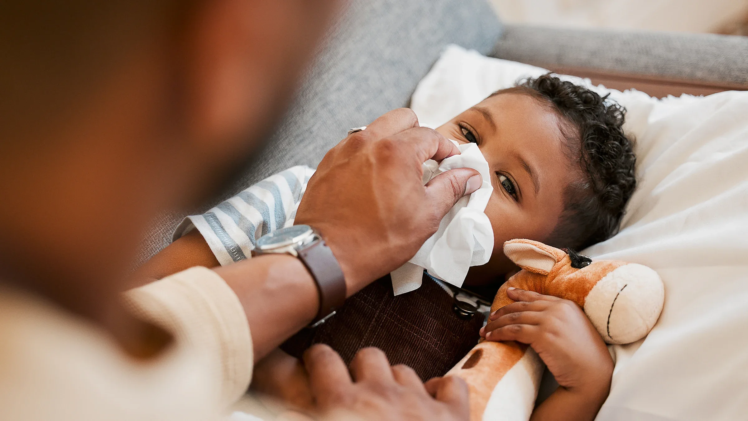 Parent wiping baby's nose with a tissue.
PeopleImages/iStock via Getty Images Plus