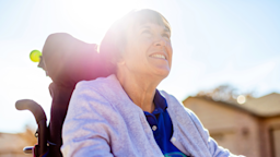 A woman in a wheelchair is looking up at the sky.
eyecrave productions/E+ via Getty Images