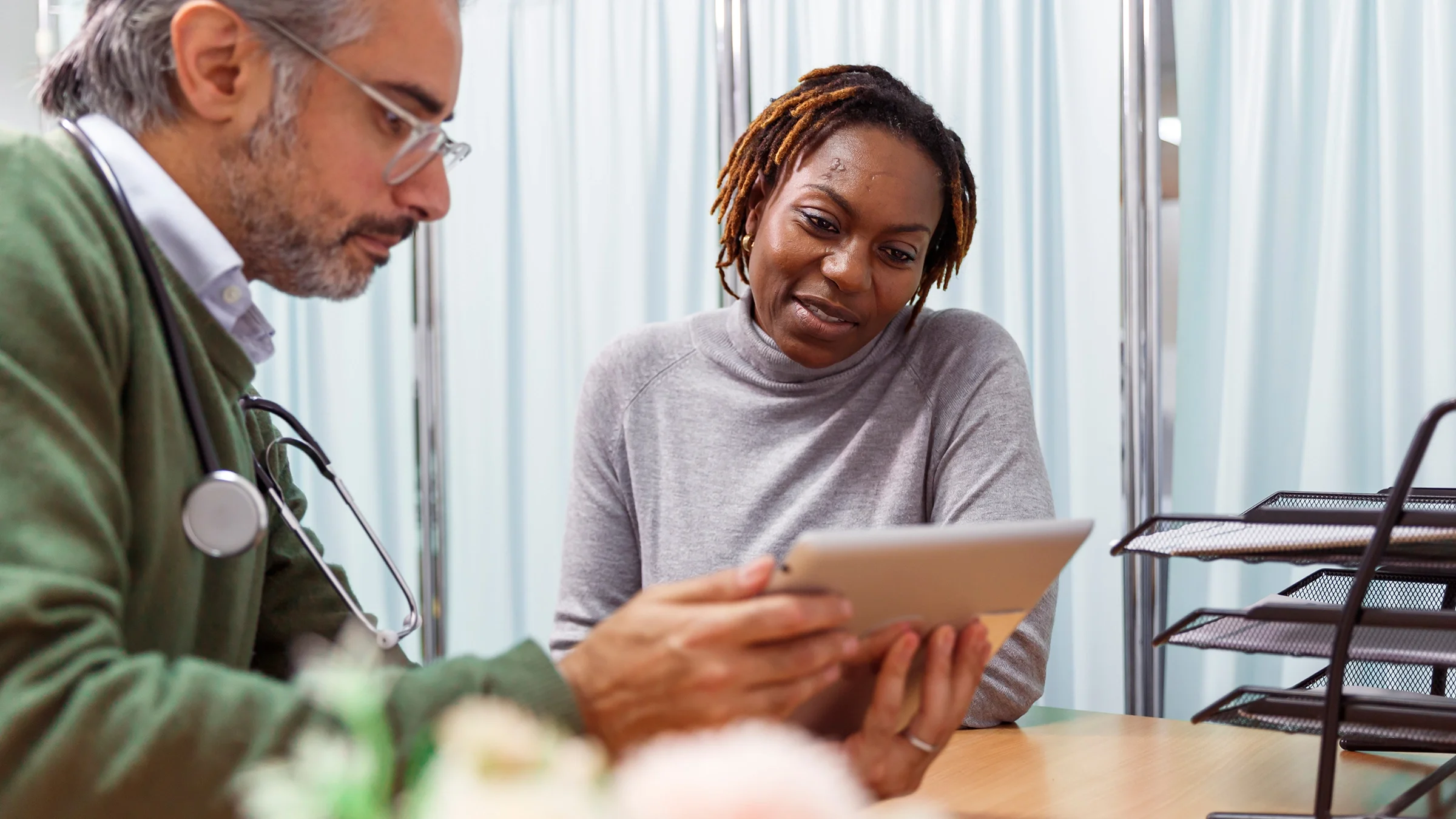A woman speaks with a healthcare professional at a medical appointment.