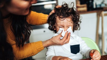 Health: Flu: mother helping child blow nose 1081701180