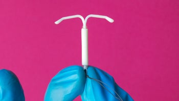Birth control: closeup IUD against pink background 1490119169