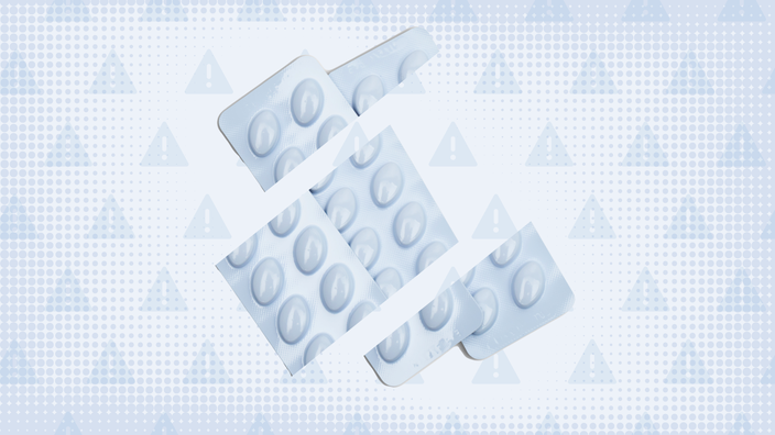 In the center of a light blue tinted background with texture and warning sign pattern are two blue-ish white blister packs of pills cut into thirds. 