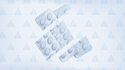 In the center of a light blue tinted background with texture and warning sign pattern are two blue-ish white blister packs of pills cut into thirds. 
GoodRx Health