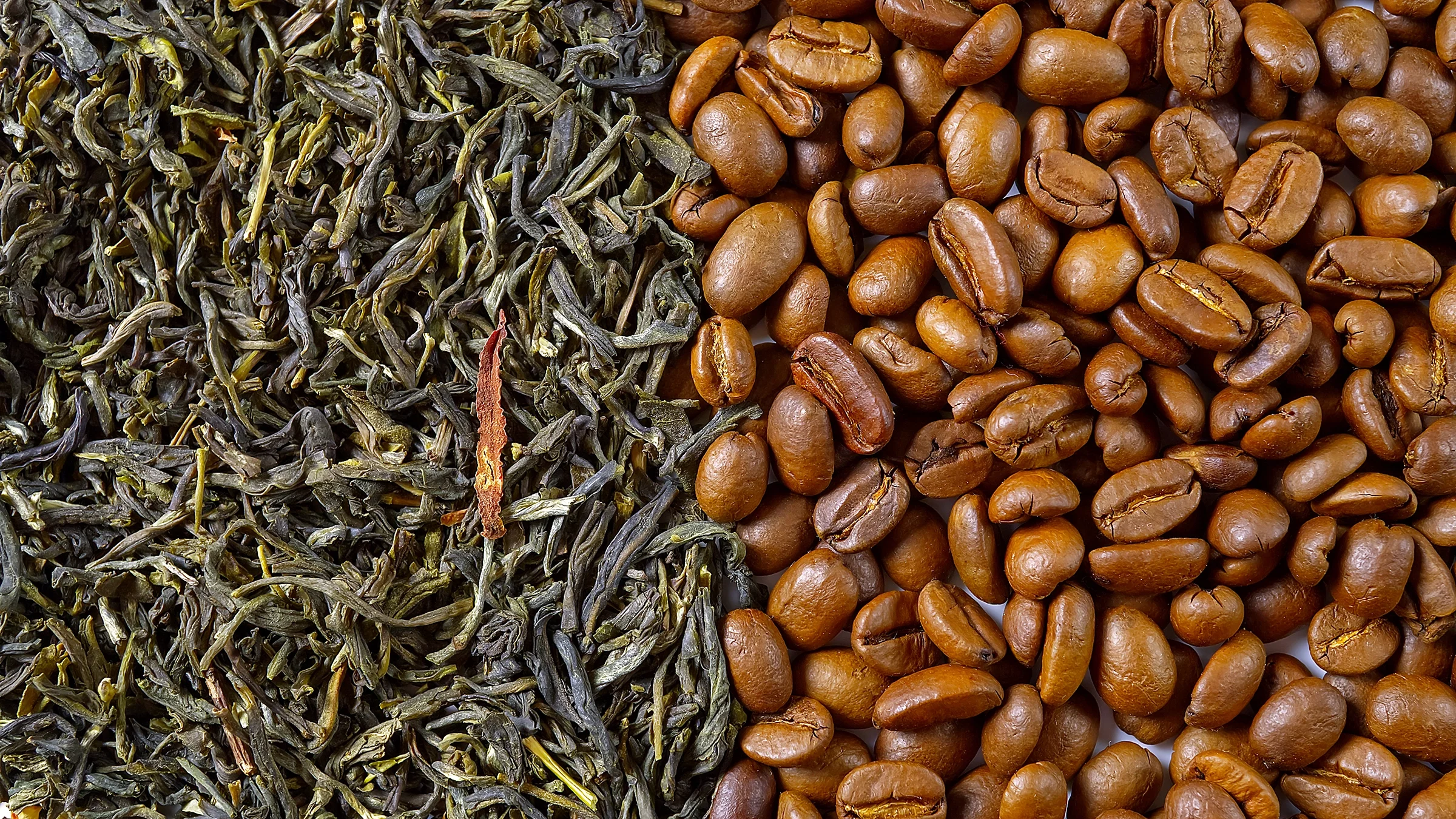 Split screen of green tea leaves on the left and coffee beans on the right.