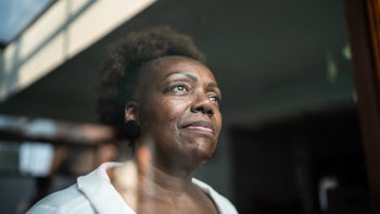 woman staring out window 1290137773