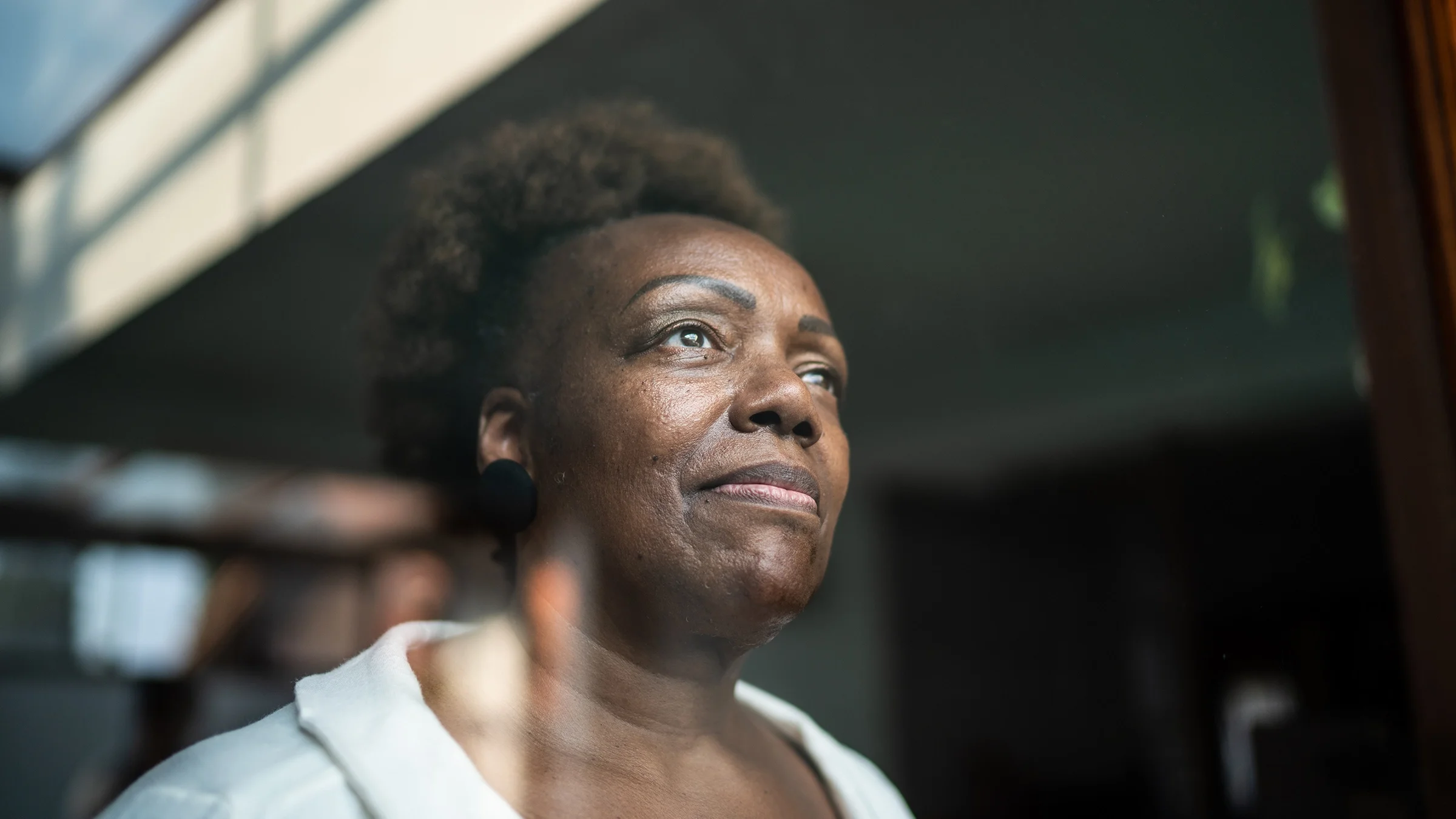 Close-up portrait of a woman staring out the window.