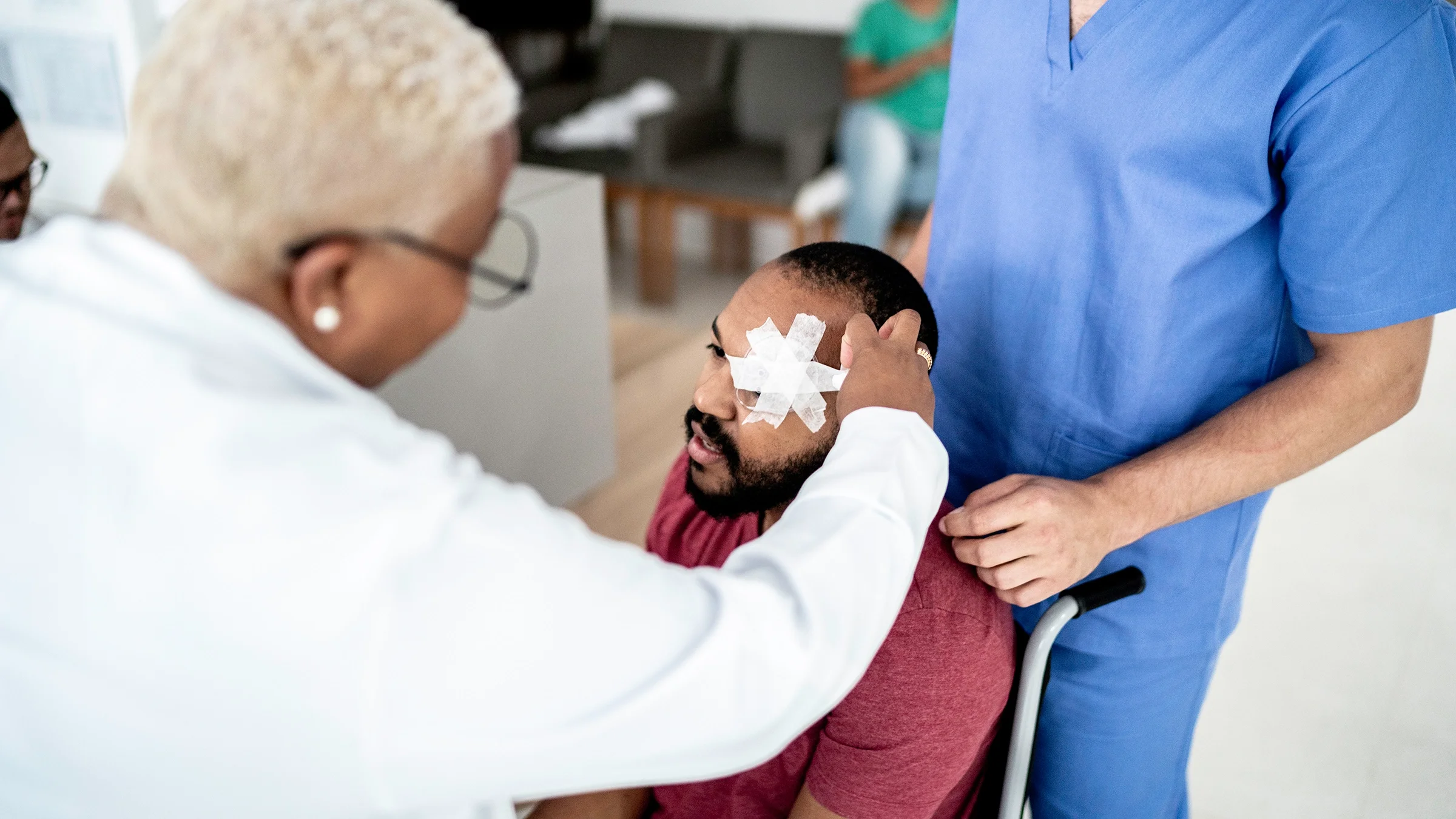 Doctor examining eye bandages on patient before releasing them from the hospital.