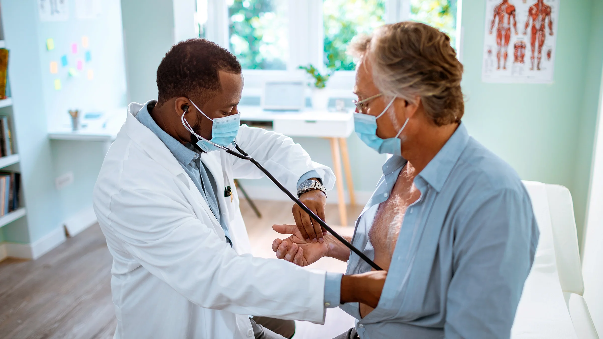 A healthcare provider is examining an older adult in the office.