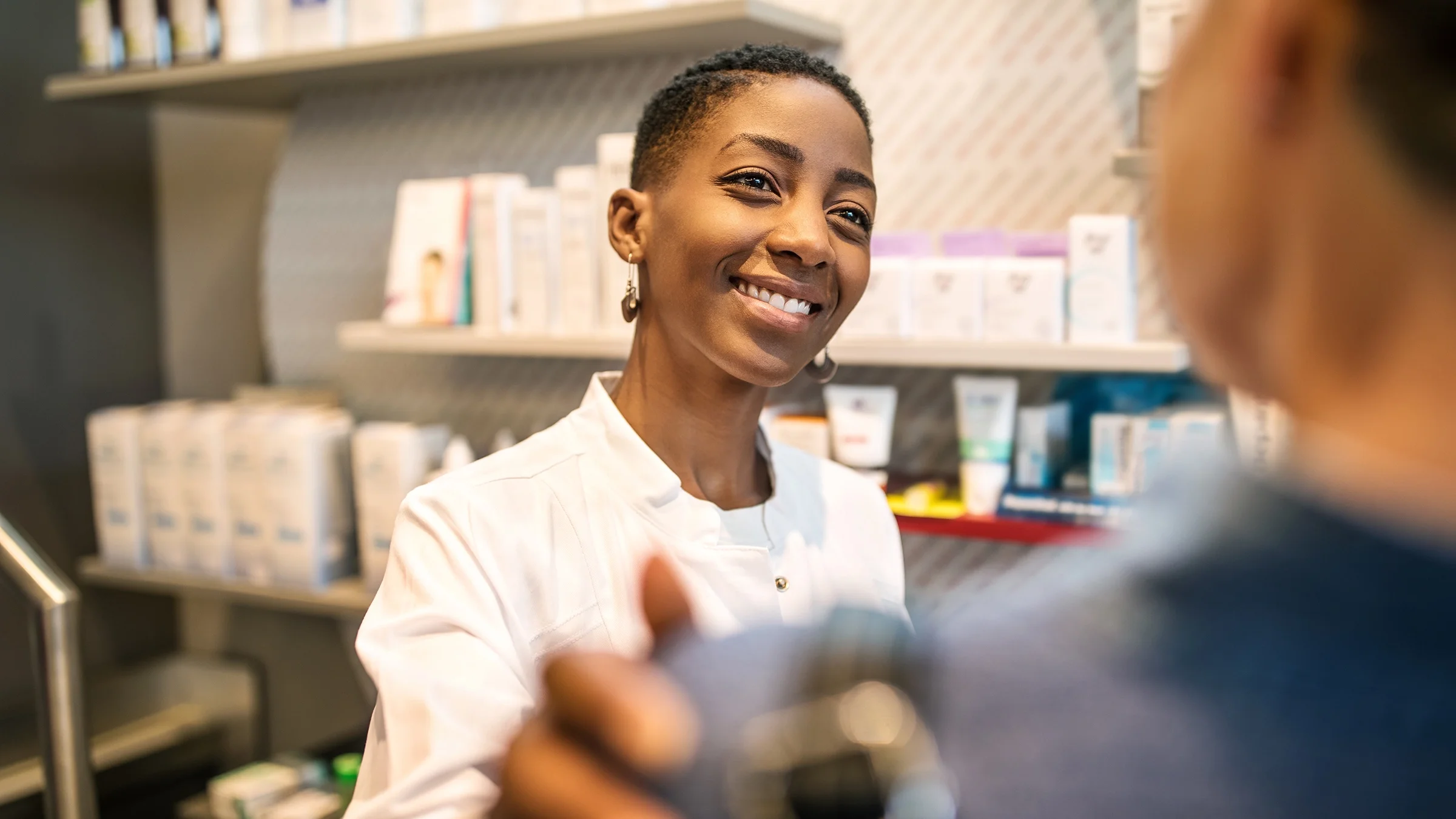 Pharmacist comforting patient in the pharmacy.