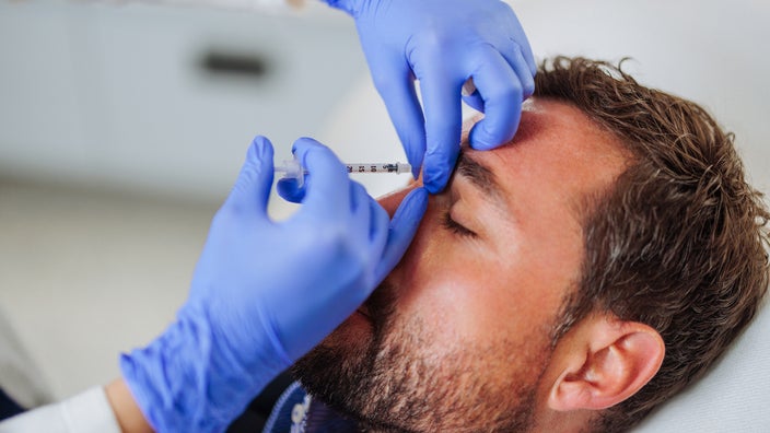 A person is getting a Botox injection in a close-up.