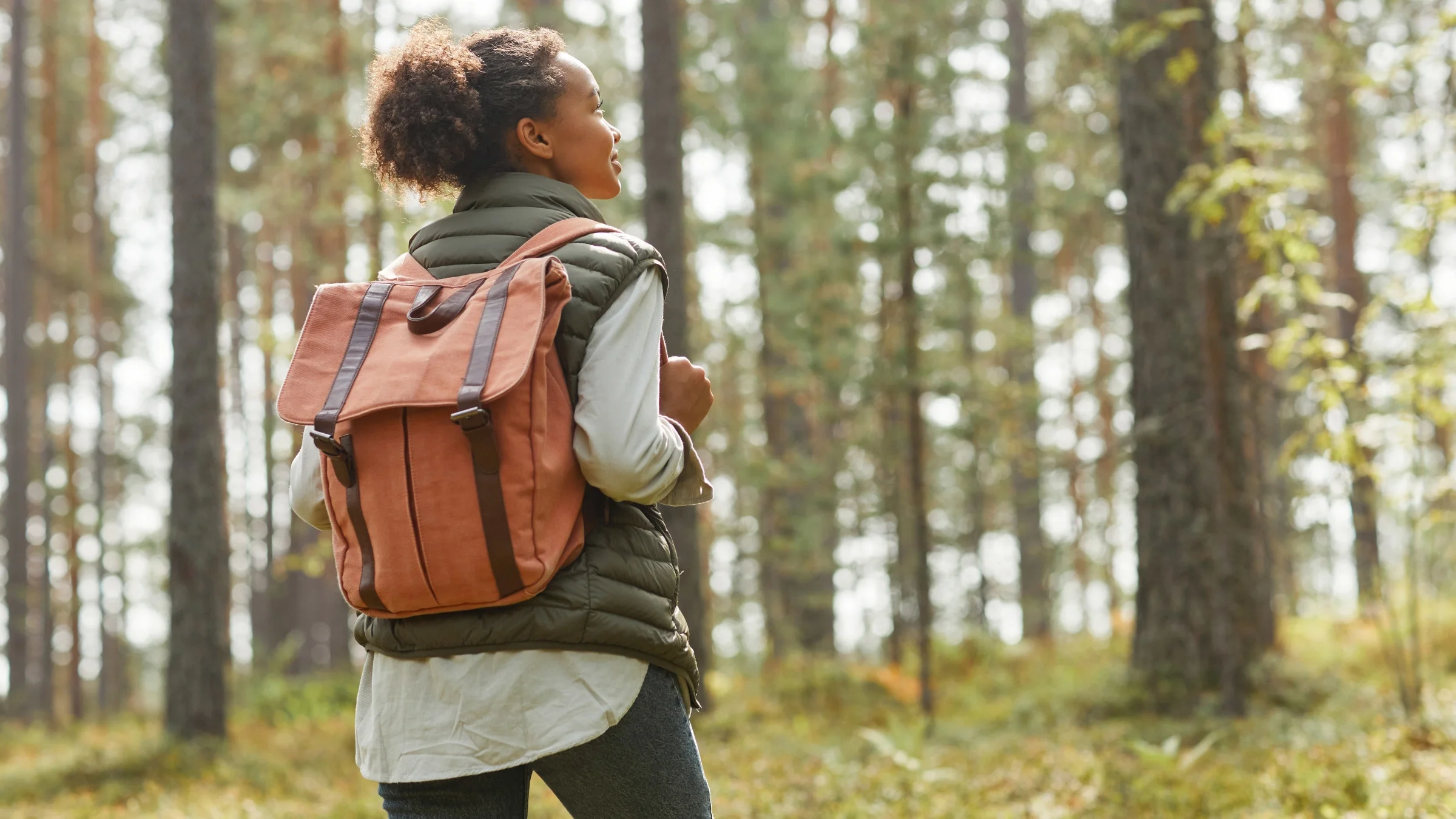 Back view of someone backpacking in a forest
