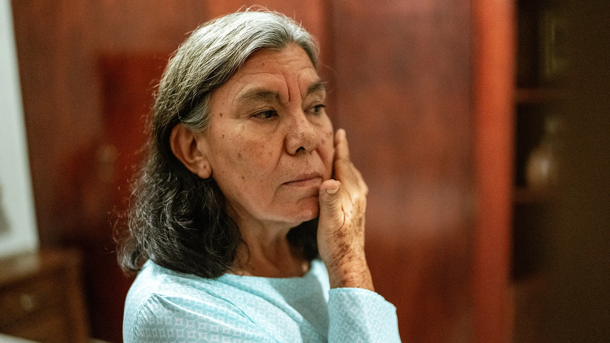 A woman applies face cream.