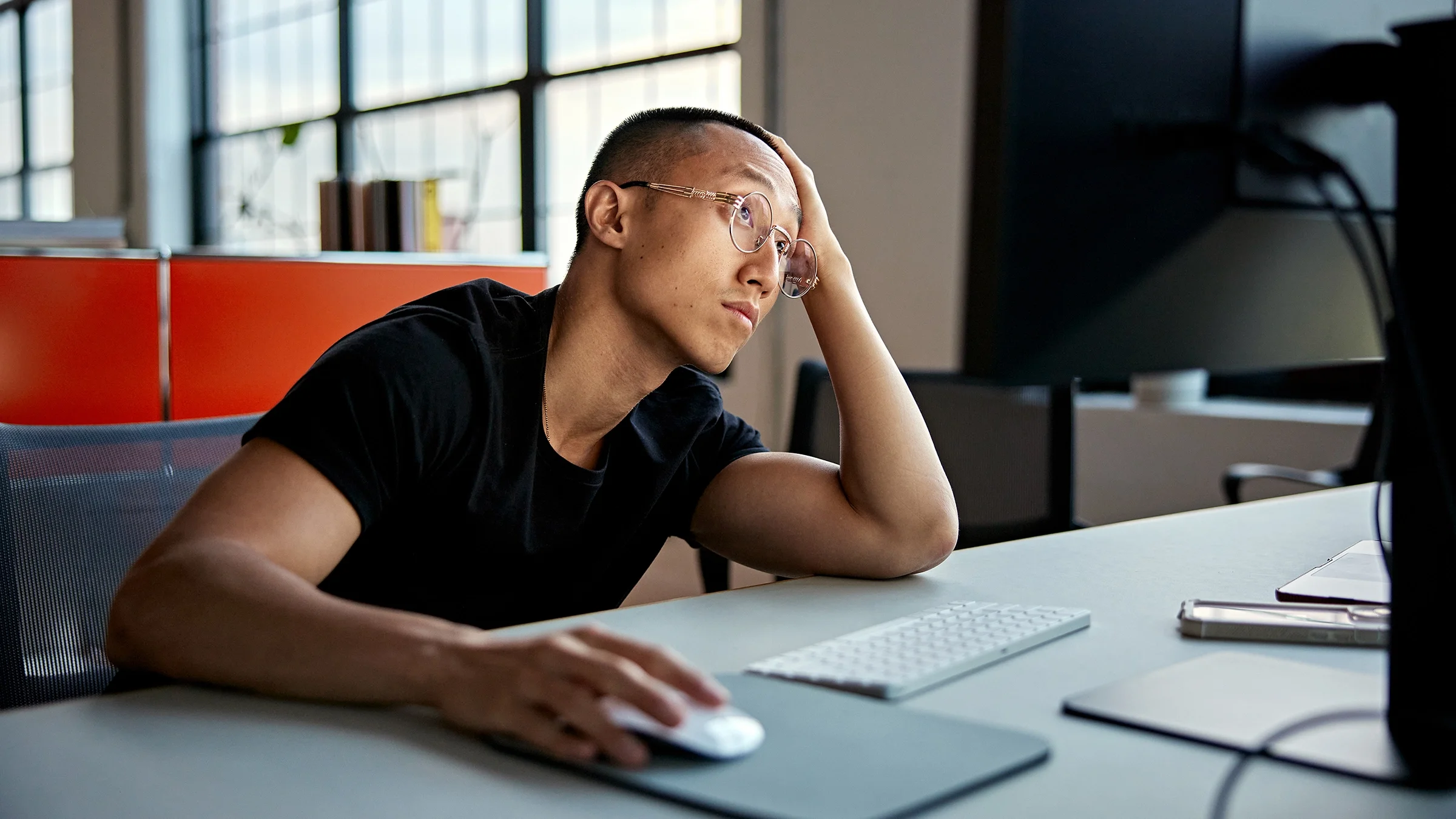 A man stares at the screen of a desktop computer.