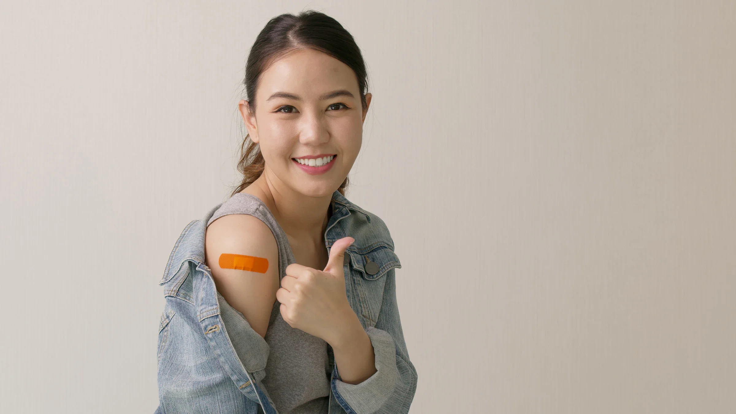 A person showing a bandaid on their arm and giving a thumbs up.
Chaay_Tee/iStock via Getty Images