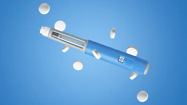 GLP-1: weightloss pen and pills on blue background 2265989306