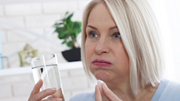 A woman prepares to take her medication.
Victor_69 /iStock via Getty Images Plus