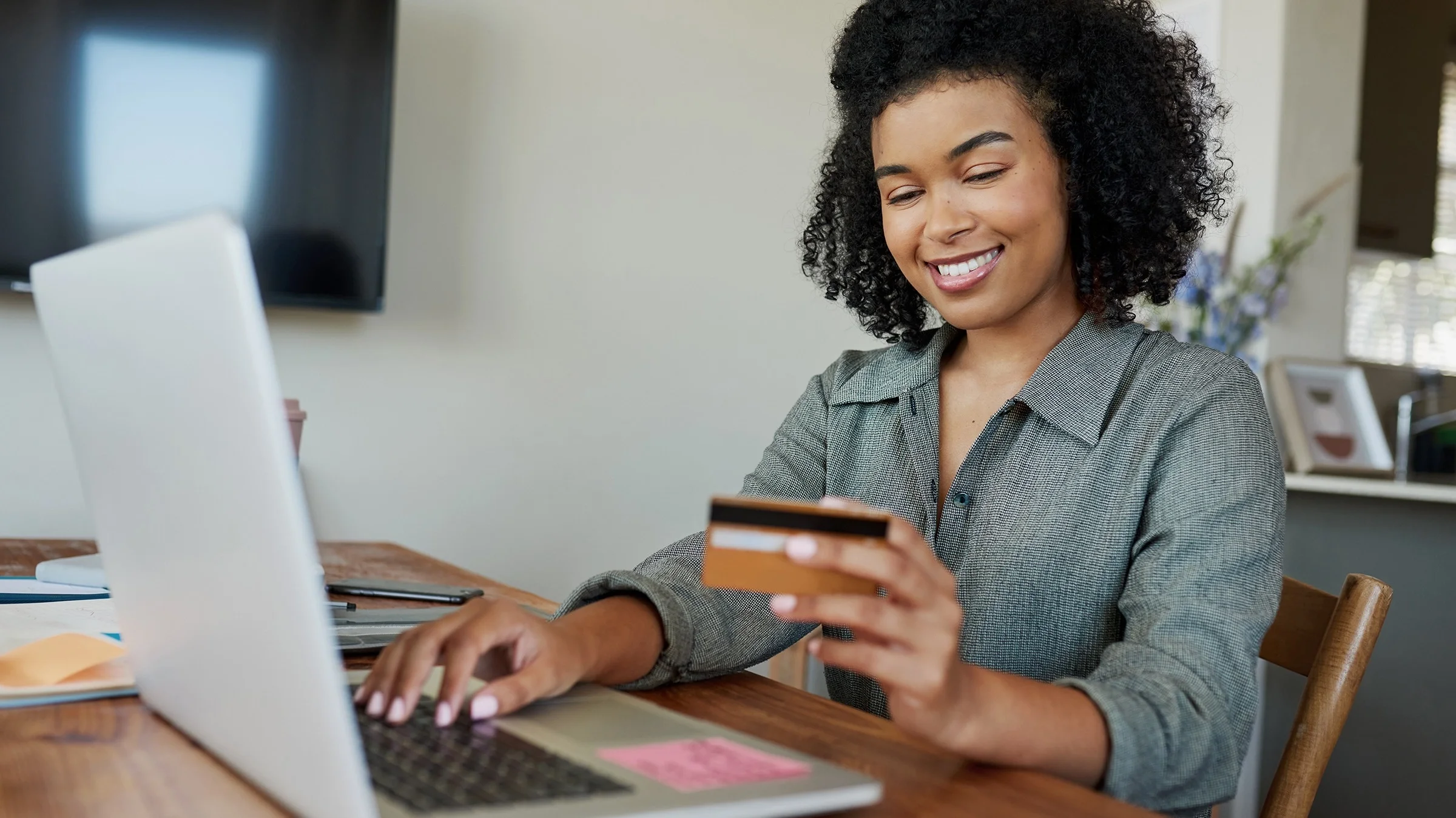 Young woman with curly hair using her FSA card on a medical bill online.