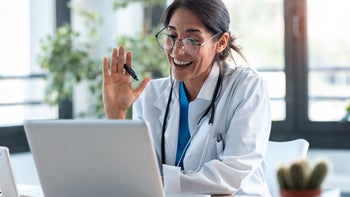 Providers: Telemedicine: doctor waving to patient in telehealth call 1249601252