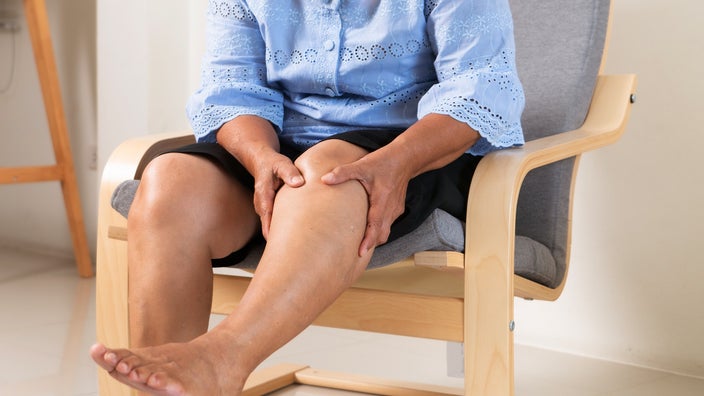 Older woman suffering from leg pain.