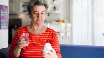 Mirtazapine: Interactions: senior woman reading rx bottle 1044437080