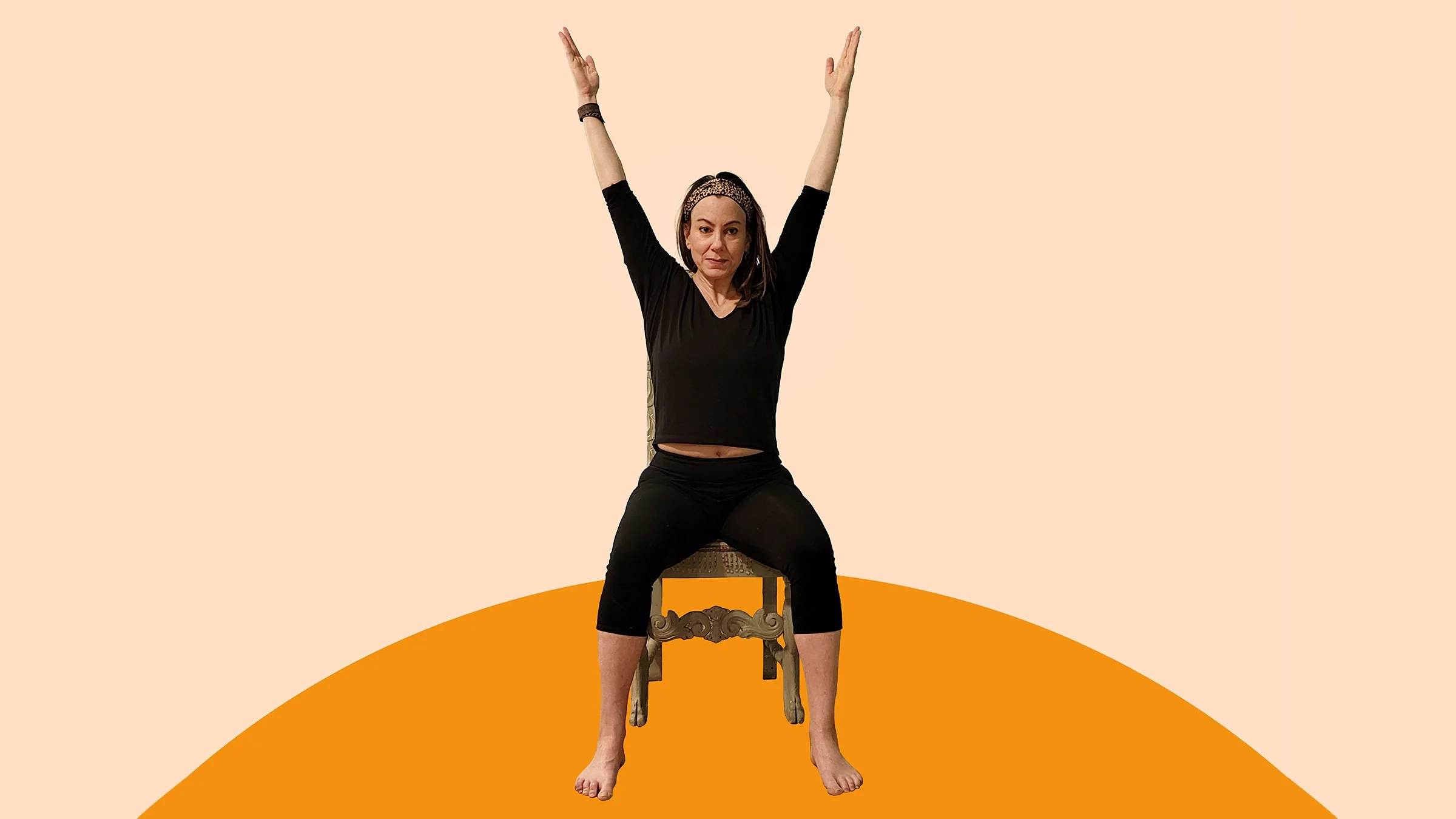 A woman does seated jumping jacks. 