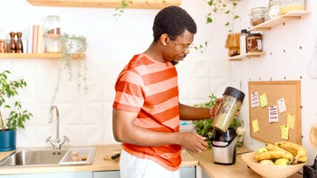 diet-nutrition: man using a blender for a smoothie 2163216576