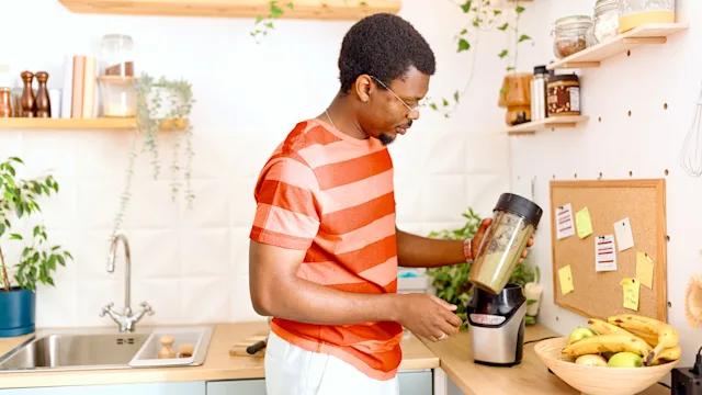 diet-nutrition: man using a blender for a smoothie 2163216576