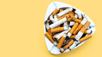 Health: Nicotrol: cigarette butts in ash tray yellow background-1324684927