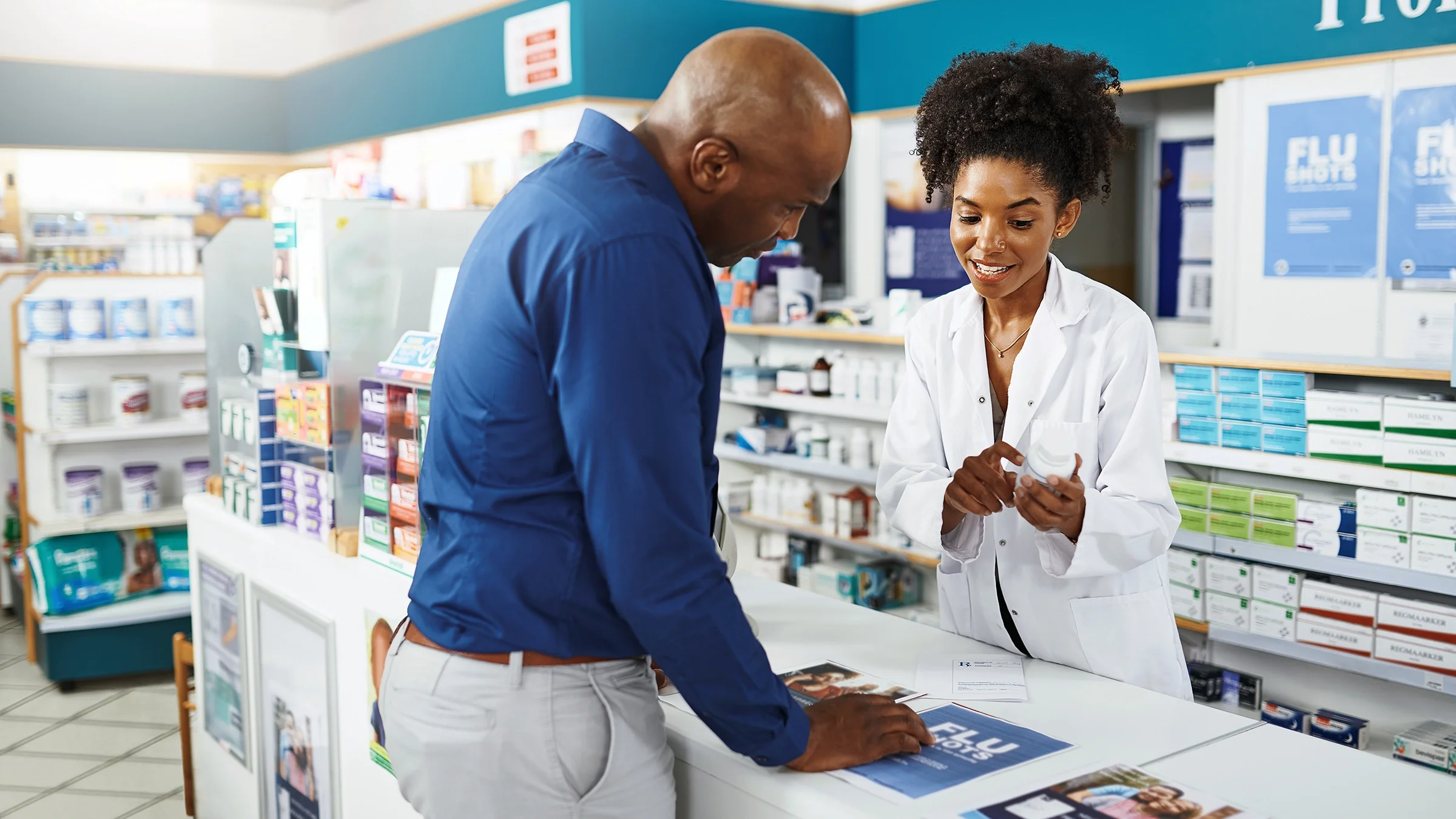 A customer speaks to a pharmacist about a medication at the pharmacy counter.