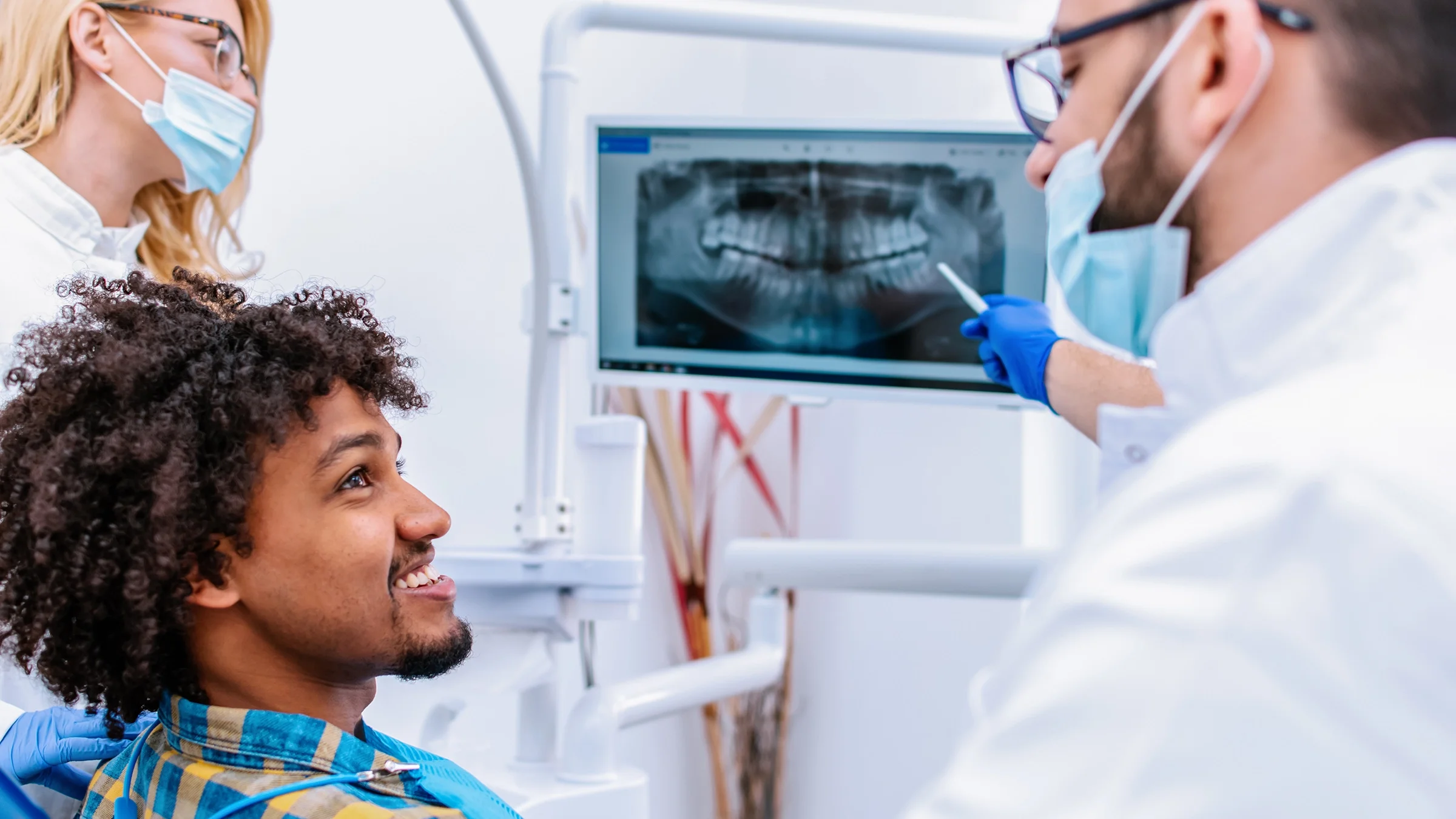 Dentist reviewing x-rays with his smiling patient.