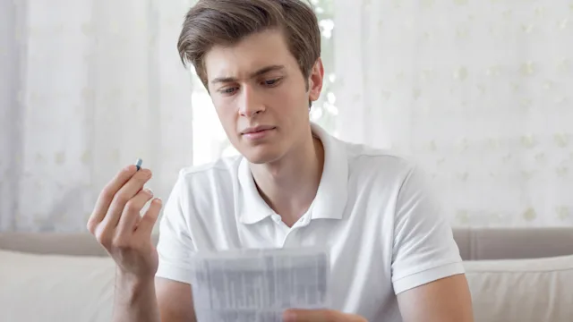 Smoking cessation: Pill: 	holding-pill-reading-label-1188225988.jpg