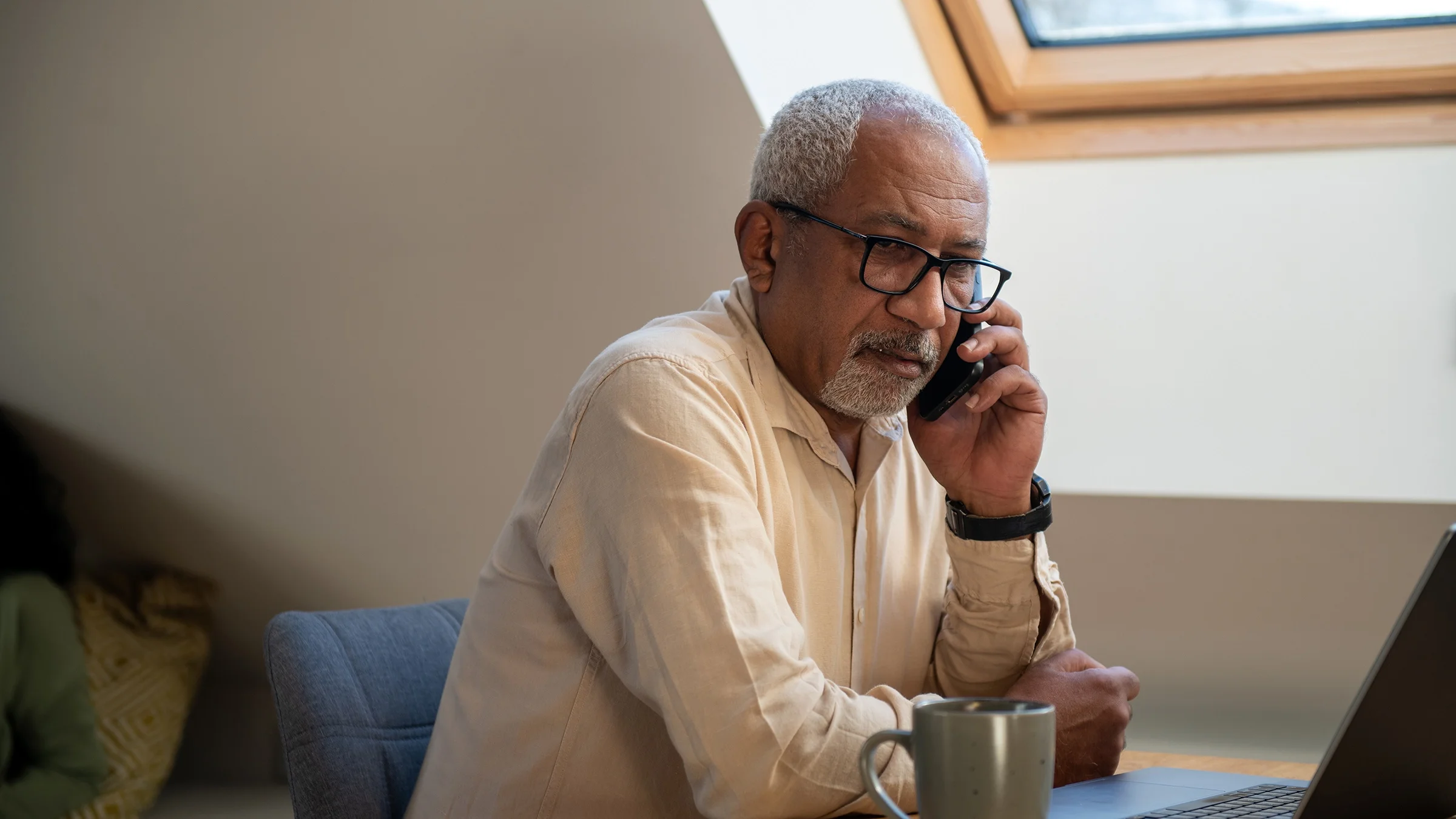 An older man speaks on his mobile phone.