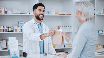drug cost: handing prescription to customer 1731604795