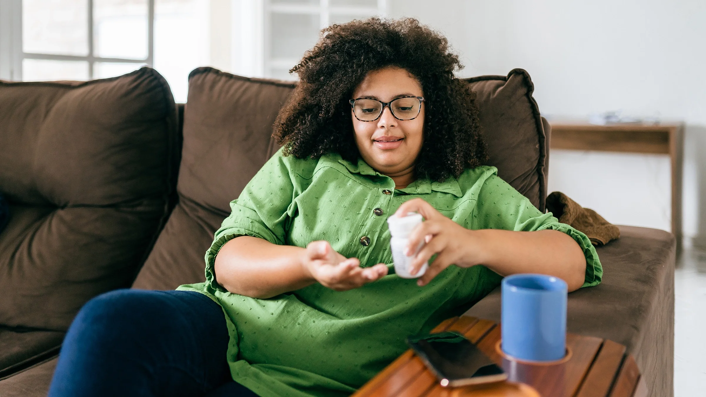 Woman taking medicine at home