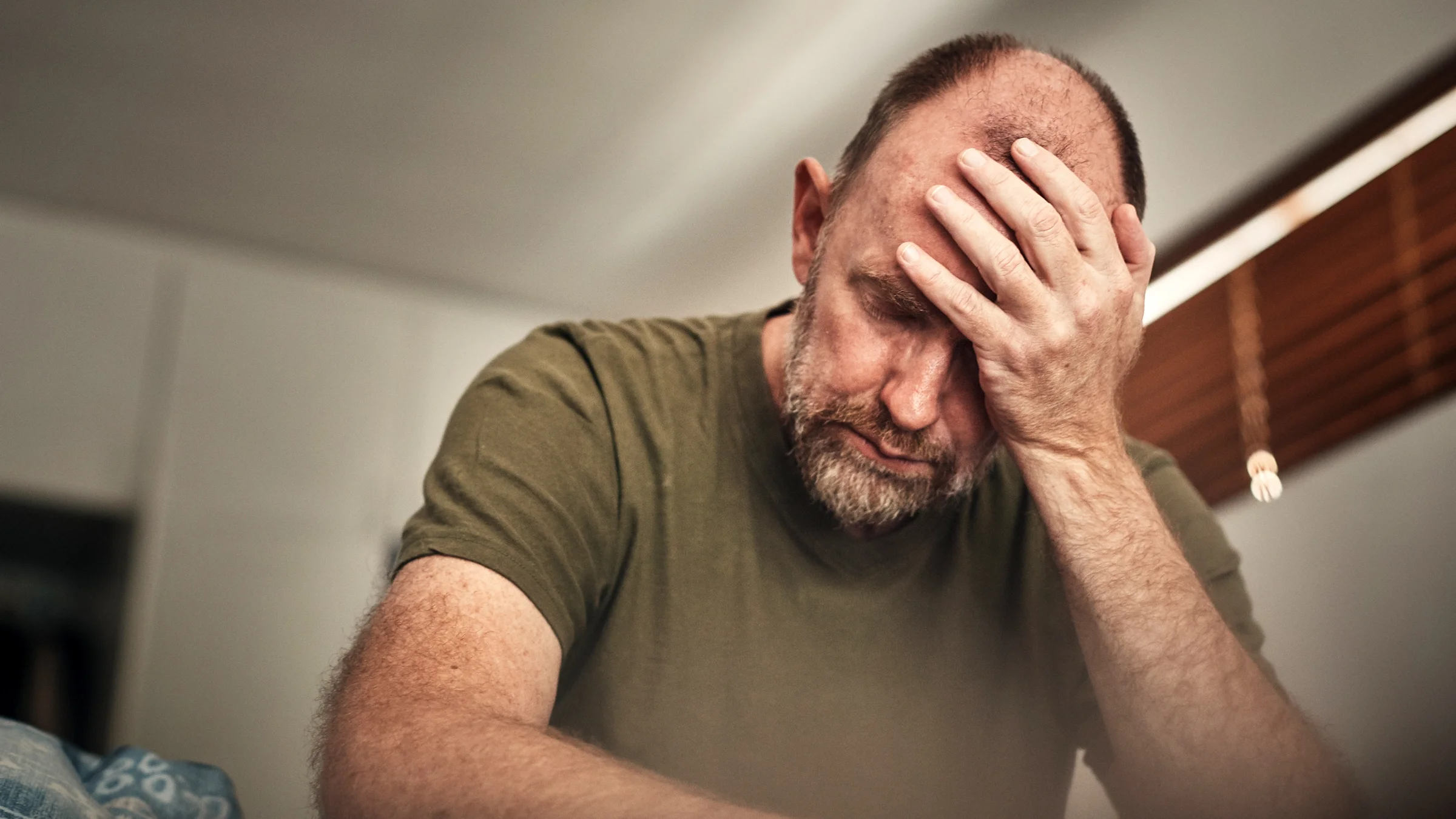 A man with depression in his bedroom.