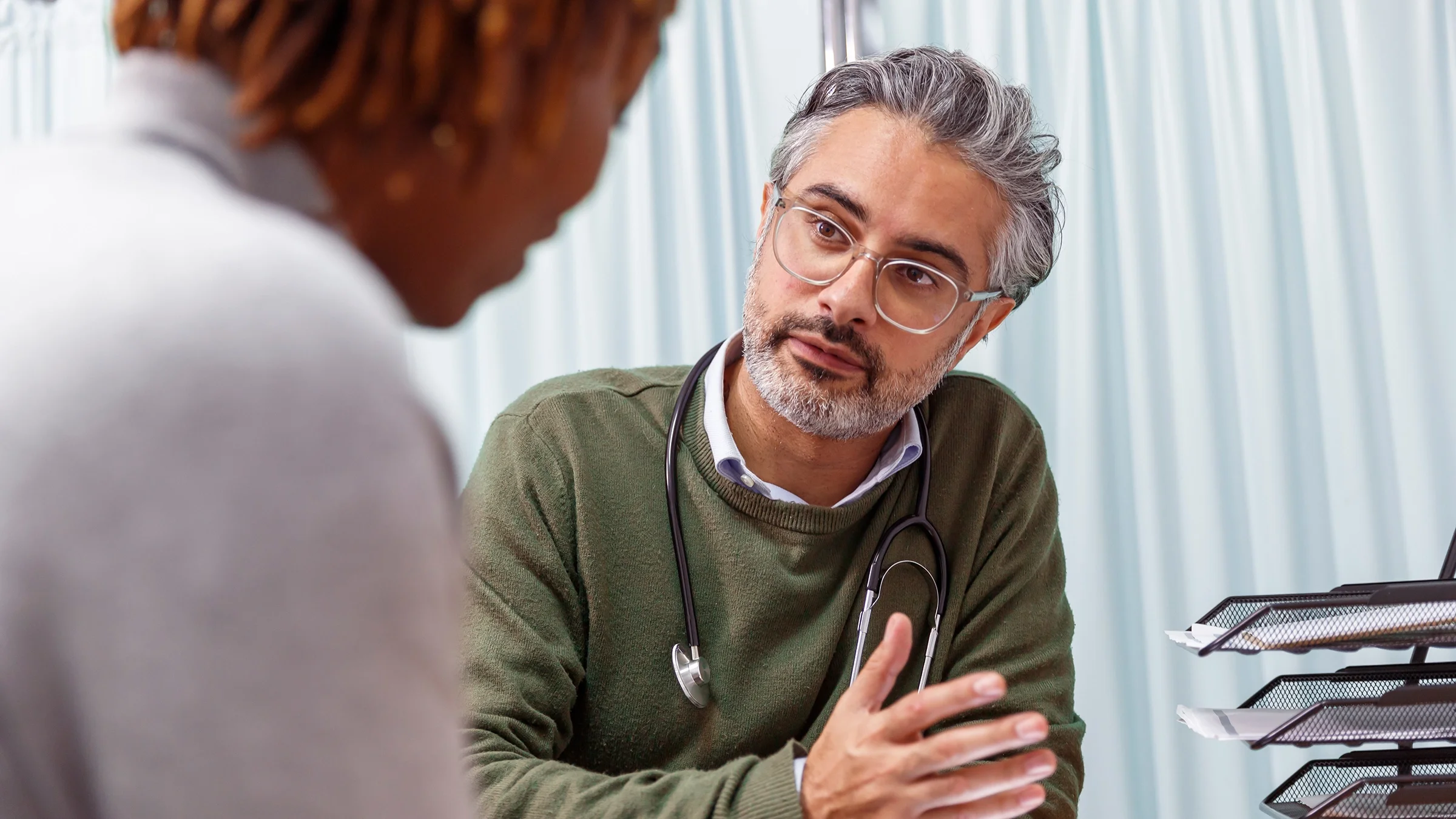 A healthcare professional consults with a patient in a medical office.