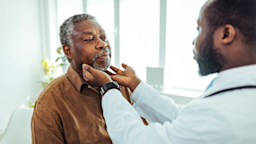 A healthcare provider performs a thyroid examination on a patient.
ljubaphoto/E+ via Getty Images