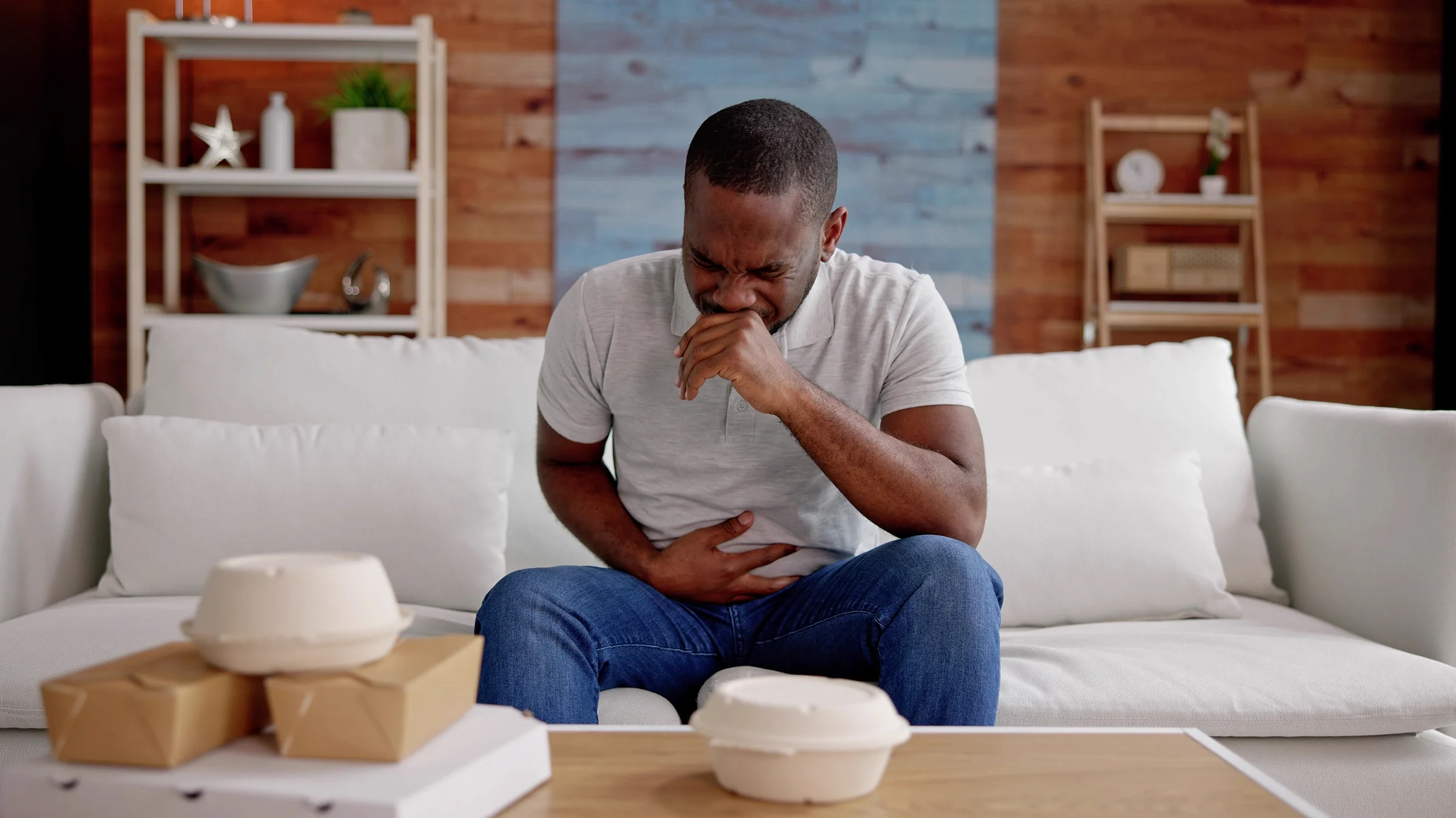 Man has an upset stomach after eating takeout.