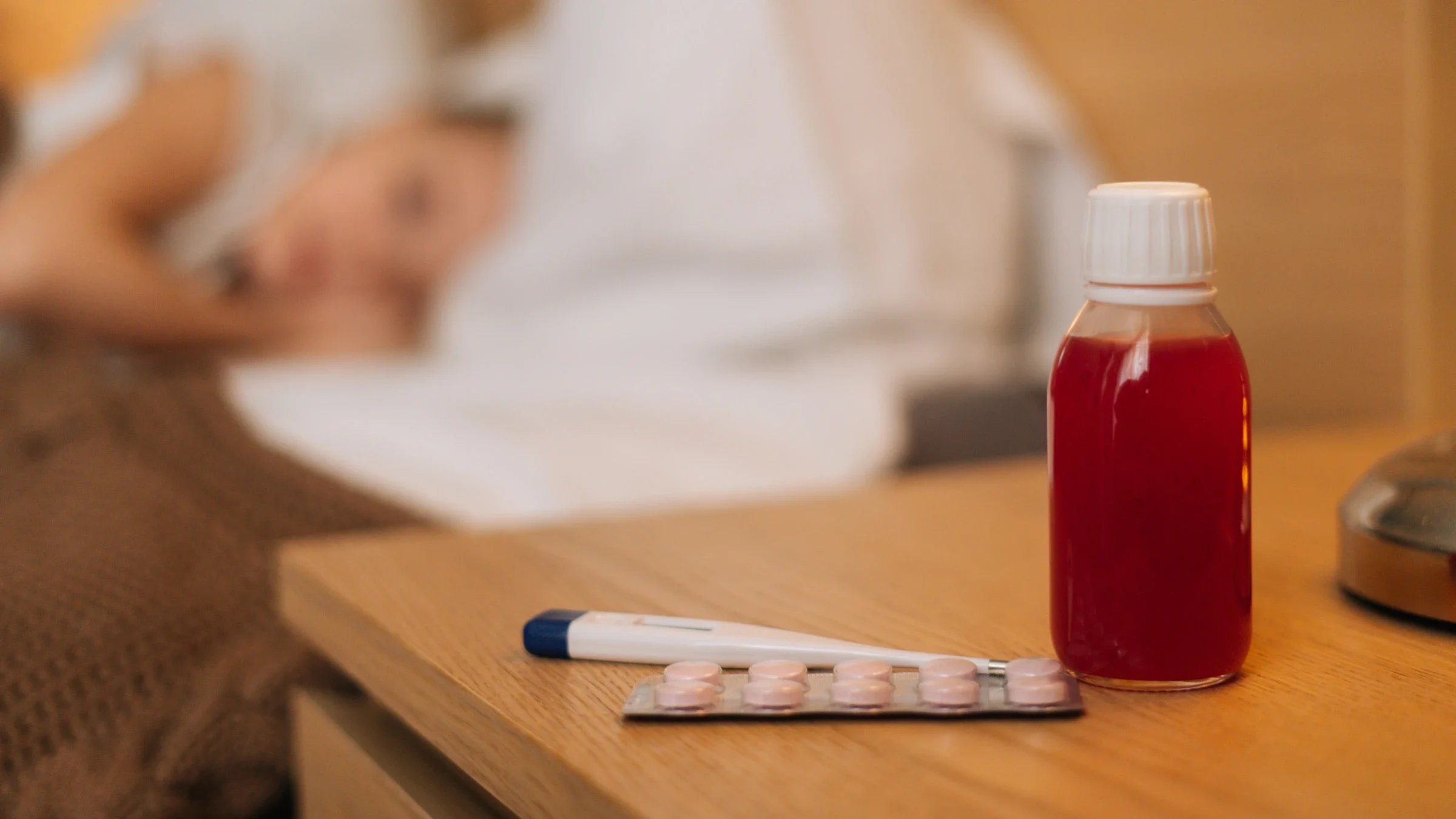 Z-Pak: cold meds thermometer on nightstand blurred sick person 1360004331