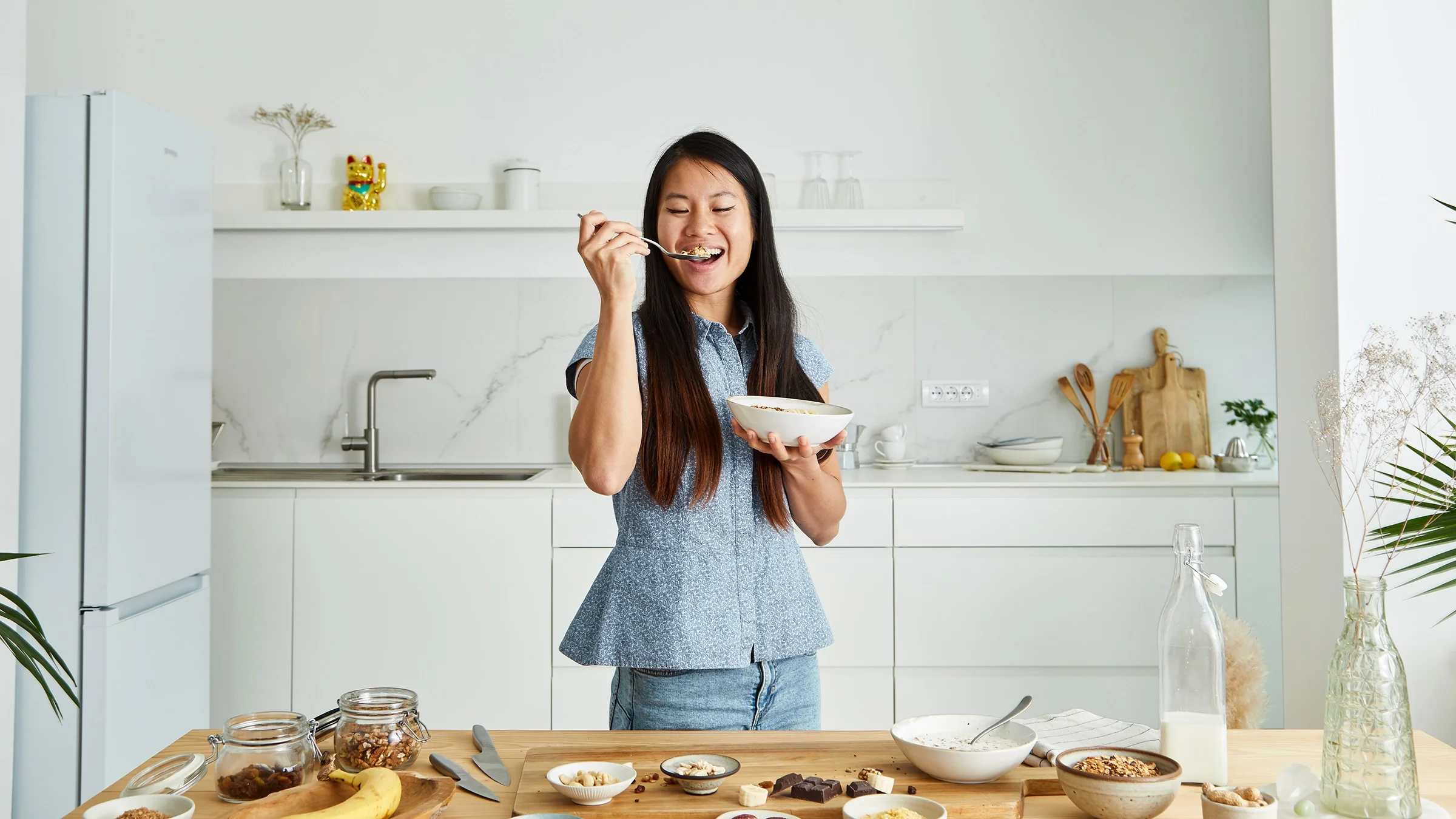 A woman eats oatmeal in her kitchen. Eating oatmeal is a healthy way to start your day. But it doesn’t contain much protein. Adding yogurt, nuts, and eggs can boost the protein content of your morning oatmeal. 