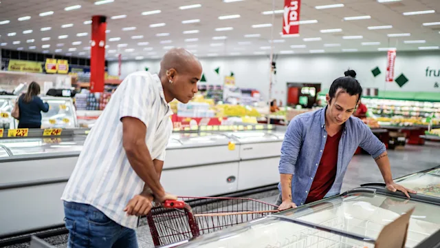 Health: Latine health: two people shopping in freezer section 1405275285