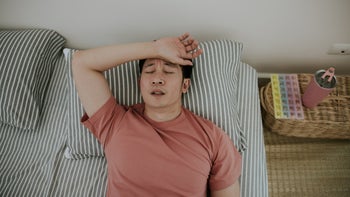 Mirtazapine: man sleeping with hand across forehead 1369091580
