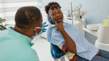 Dental care: loose tooth: dental patient pointing at mouth 1472110763