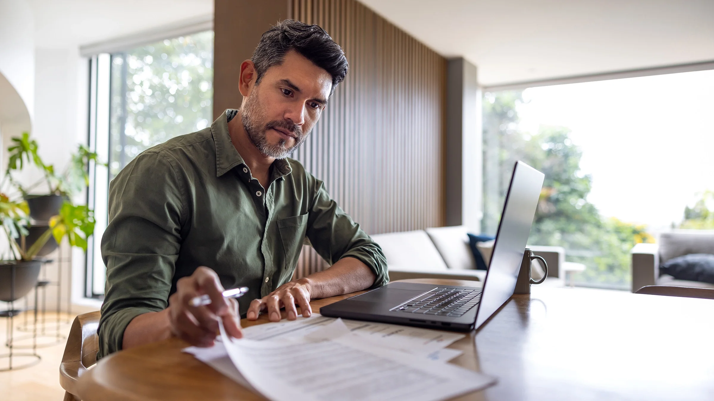 A man calculates his finances at home.