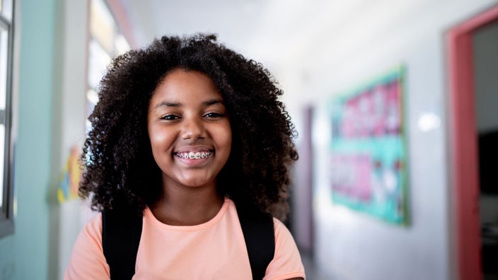 A girl with braces smiling at school.