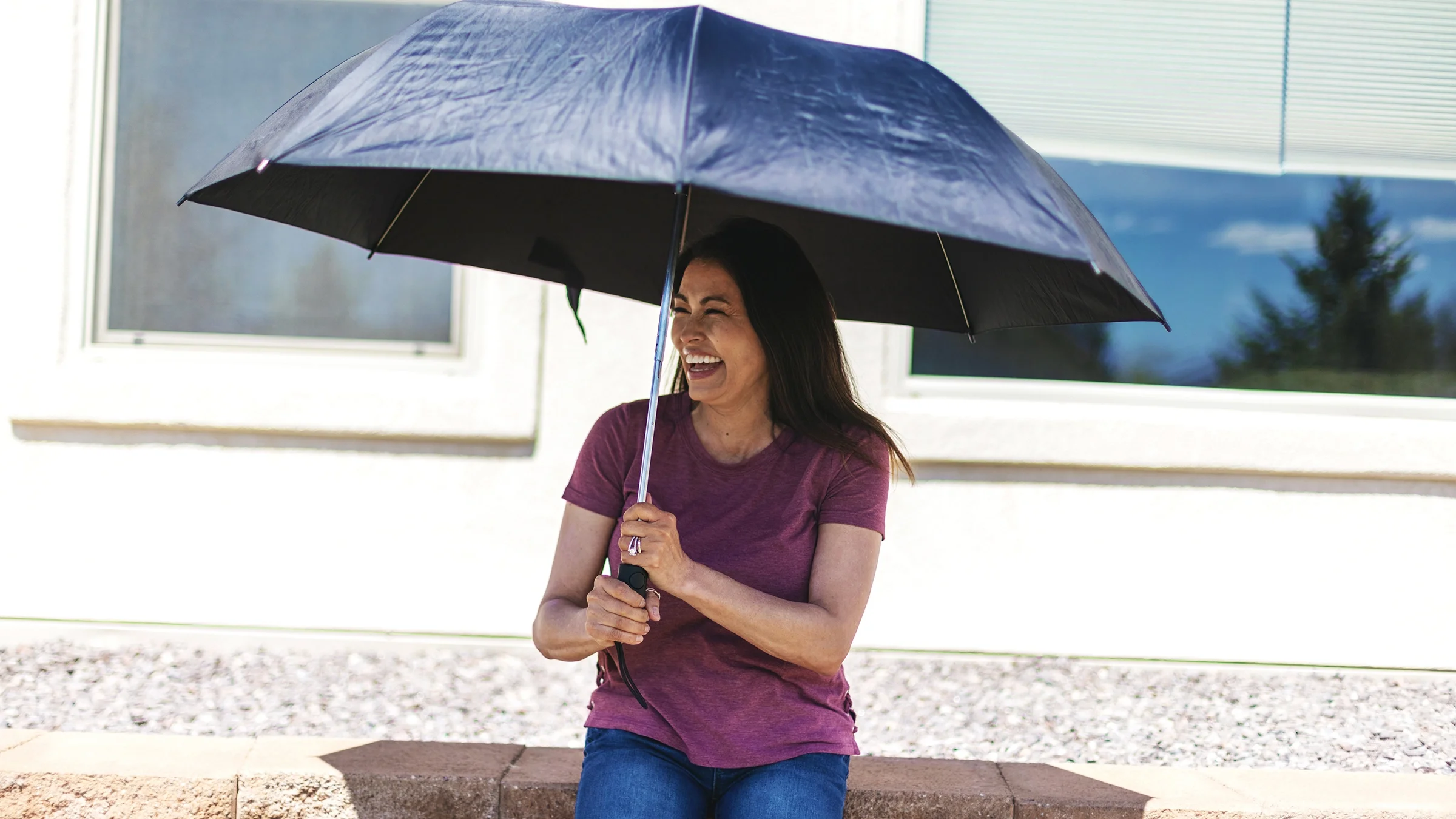 Woman sitting under an umbrella for sun protection