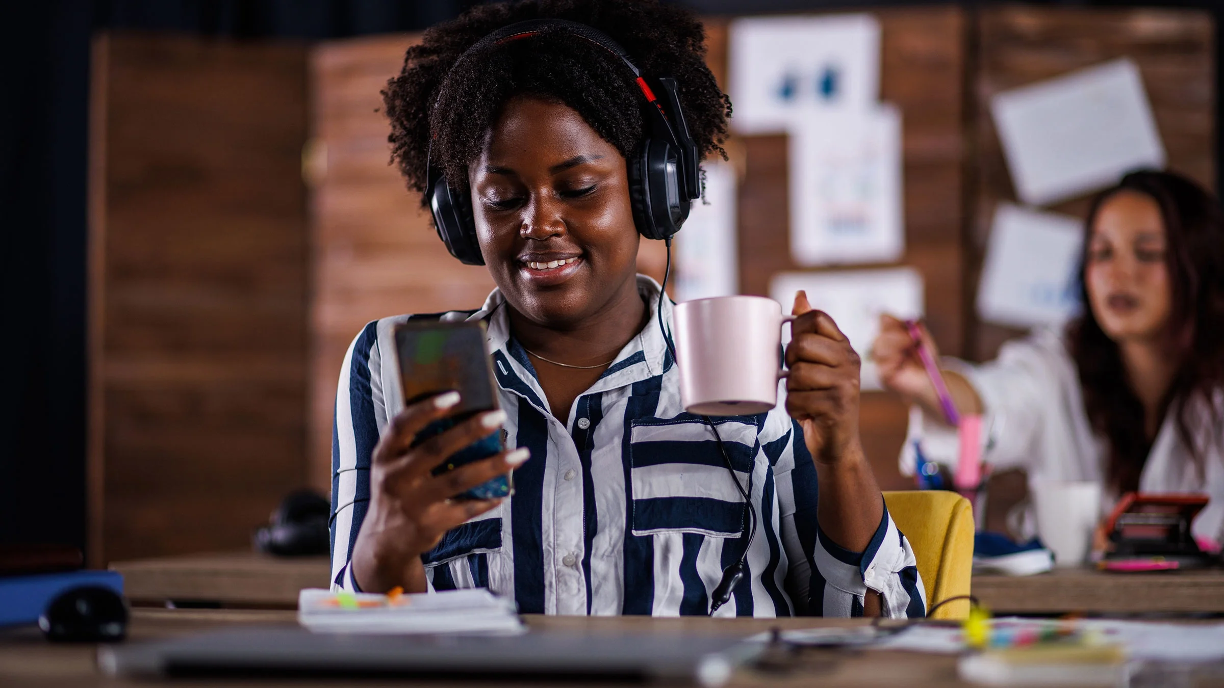 A woman with ADHD is distracted on her phone while doing homework.